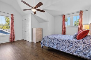 A bedroom with a bed, a dresser, a ceiling fan, and a window with curtains. - Fully Furnished 3BR East Nashville Home | 30+ Days (Nashville)