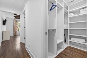 A walk-in closet with white shelving, a hanging rack, and a wooden cabinet. - Fully Furnished 3BR East Nashville Home | 30+ Days (Nashville)