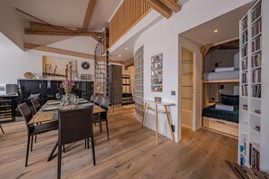 Ein modernes Interieur mit Essbereich, Schlafgalerie mit Etagenbett und Küche.