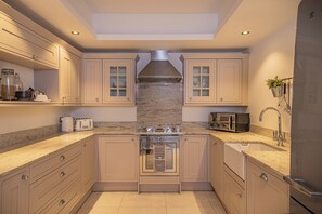 A modern kitchen with a central island, built-in oven, and stainless steel appliances. - Pointe Lachenal - Beautifully furnished apartment in the heart of Chamonix (Chamonix-Mont-Blanc)