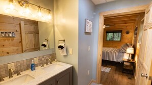 Un baño con lavamanos doble, un espejo y un perchero para toallas.
