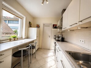 Eine kleine Küche mit Fenster, Spüle und Arbeitsplatte.