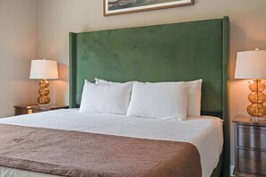 A hotel room with a large bed, two bedside tables, and a green headboard. - Sevierville Cabin Near Dollywood, Sleeps 6, Hot Tub (Sevierville)