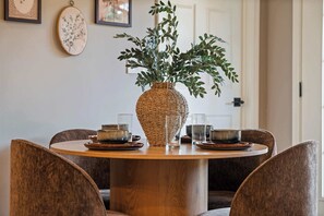 A round wooden dining table with a woven vase centerpiece, surrounded by six chairs. - Sevierville Cabin Near Dollywood, Sleeps 6, Hot Tub (Sevierville)
