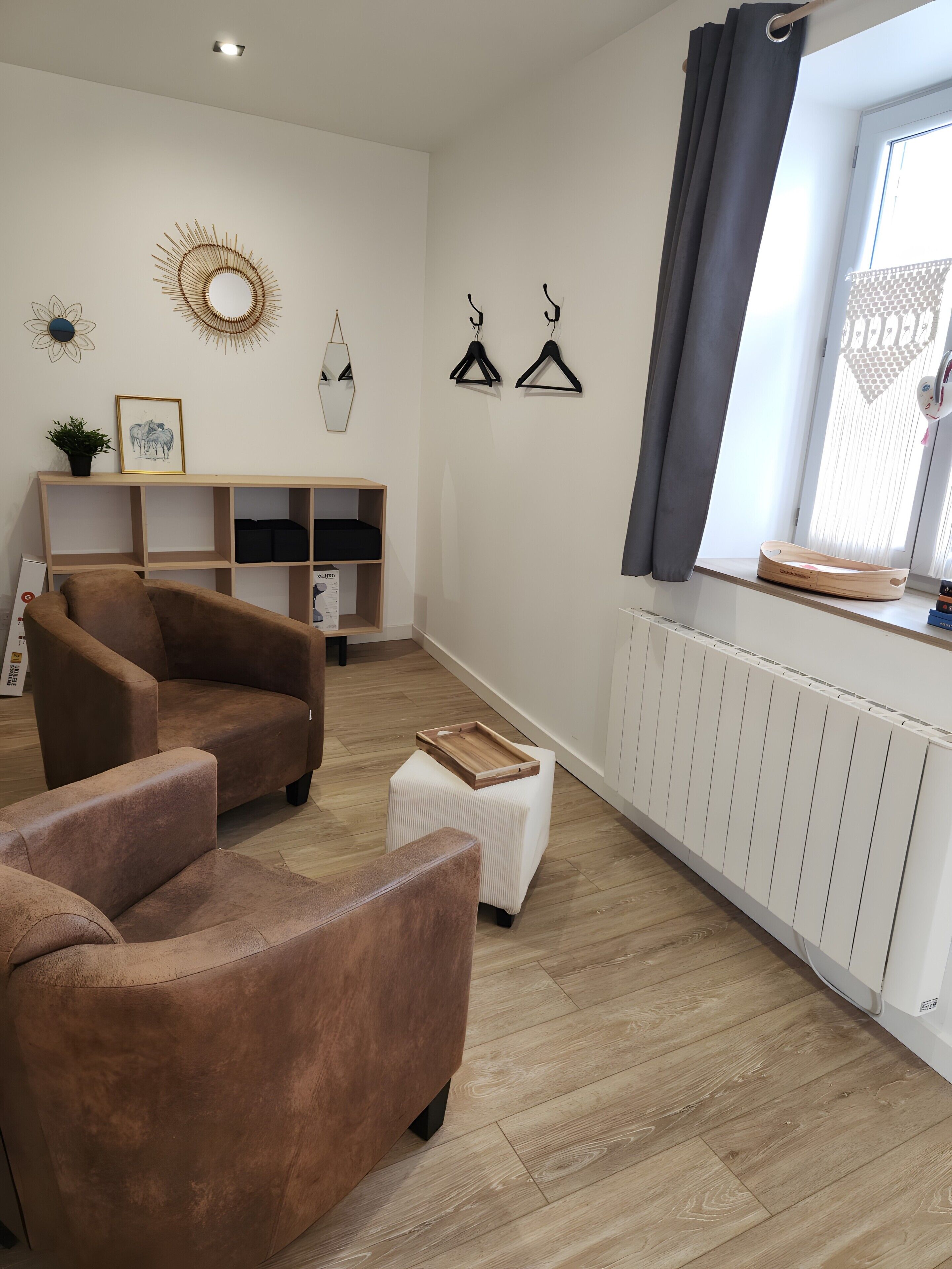 Ein modernes Wohnzimmer mit einer Couch, einem kleinen Hocker und einer Heizung.