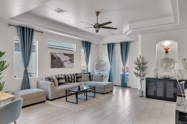 A modern living room with a sofa, coffee table, and a hanging chair.