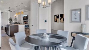 A modern kitchen with a central island, pendant lighting, and a dining area with a round table and chairs. - Modern Rio Rancho - Fireplace, Private Yard (Rio Rancho)