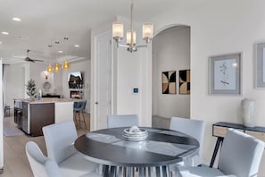 A modern kitchen with a central island, pendant lighting, and a dining area with a round table and chairs. - Modern Rio Rancho - Fireplace, Private Yard (Rio Rancho)