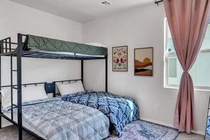 A bunk bed room with a window and two wall art pieces. - Modern Rio Rancho - Fireplace, Private Yard (Rio Rancho)
