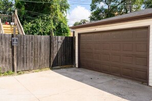A residential garage with a wooden fence and a 'RESERVED' sign. - Fun Gaming Apartment w/Free Parking (Chicago)