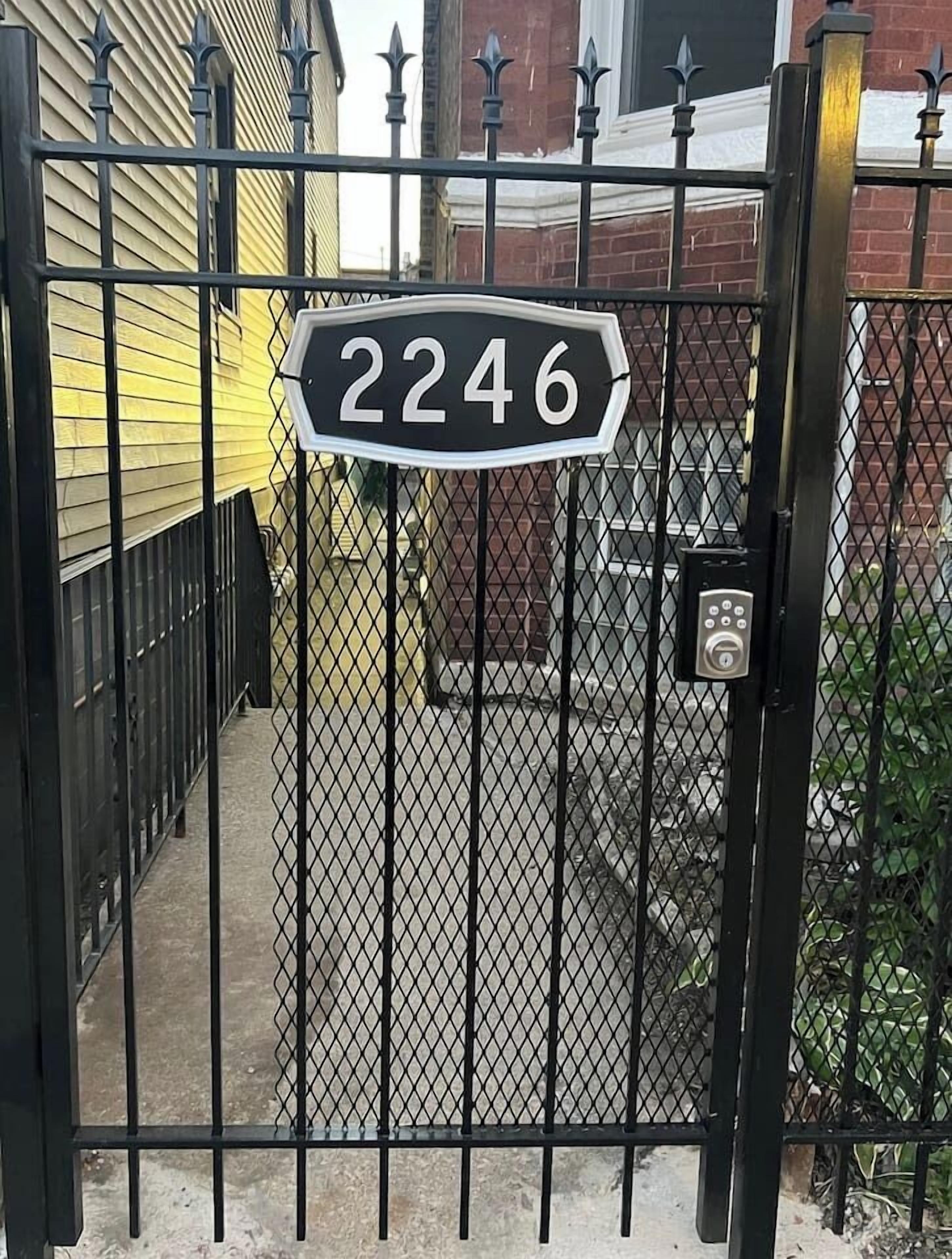 Une propriété privée, fermée par un portail, avec une plaque indiquant le numéro de la maison.