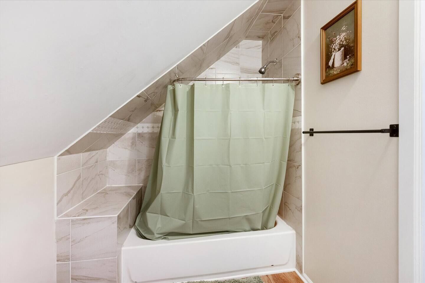 A bathroom with a shower curtain, a bathtub, and a tiled wall.