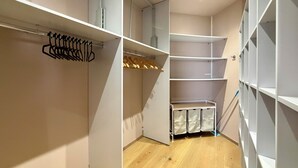 A walk-in closet with open shelving, a hanging rod, and a shoe rack.