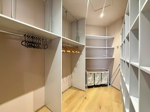 A walk-in closet with open shelving, a hanging rod, and a shoe rack.