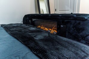 A room with a bed, a fireplace, and a mirror on the wall. - Atlanta Luxe Stay (Atlanta)