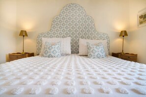 A bed with a patterned headboard and two bedside lamps, set against a plain wall. - Brantside, Central Ambleside, Panoramic Views (Ambleside)