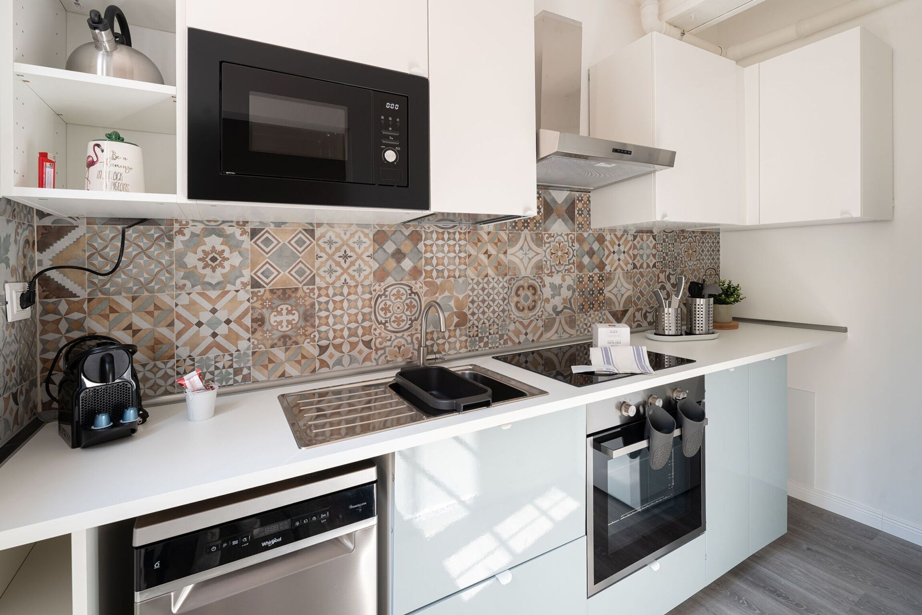 Una cucina moderna con forno a microonde, lavastoviglie e forno.