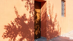 Entrada de un edificio con puerta de madera y ventana con rejas de metal.