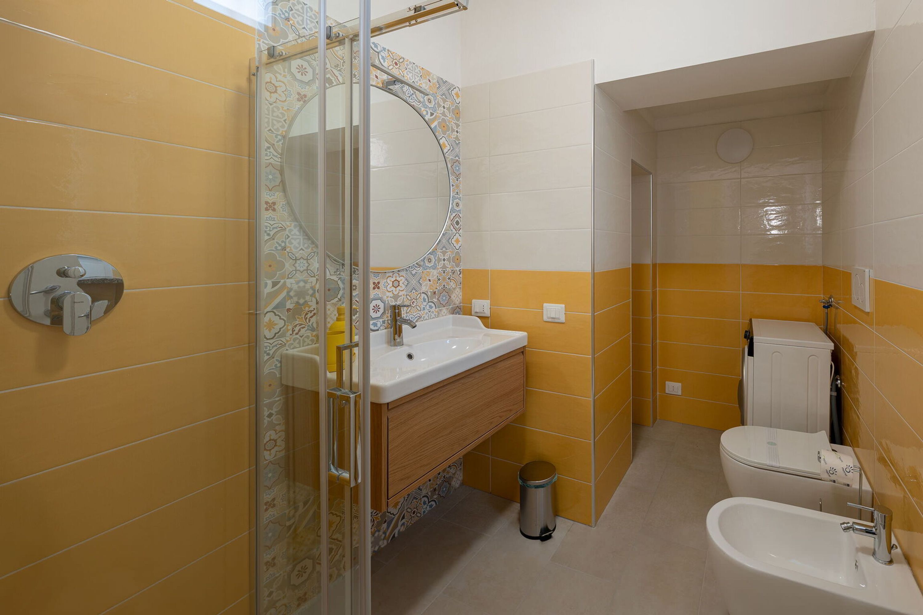 Un bagno con doccia, lavandino, WC e bidet.