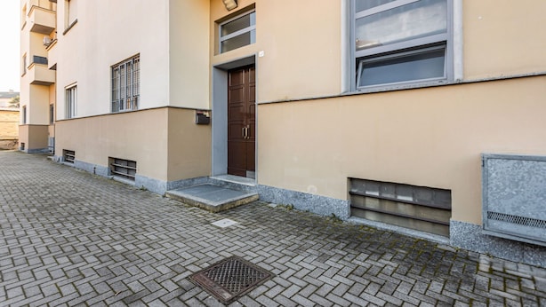 Un edificio con entrada a nivel de calle, una puerta y una ventana con reja de metal.