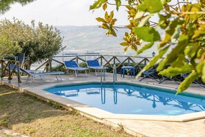 Una piscina con lettini e vista sul paesaggio.