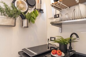 A kitchen with a countertop, a sink, a stove, and various kitchen utensils. - Maison D Alice in Firenze (Florence)