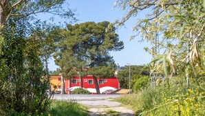 Een pad dat leidt naar een rood gebouw met een bord waarop staat dat het een hotel en bar is.