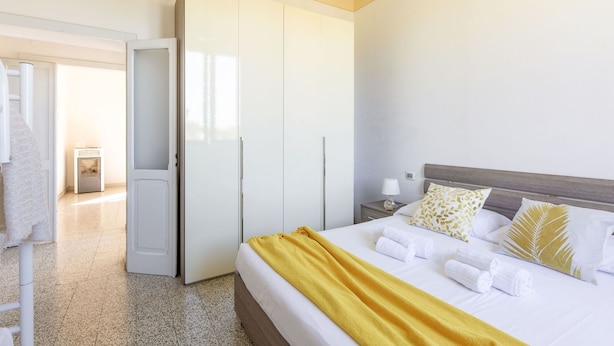 Een hotelkamer met een bed, een kledingkast, een nachtkastje en een badkamer.