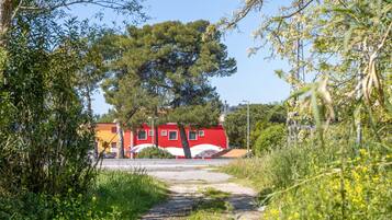 A pathway leading to a red building with a sign indicating it is a hotel and bar.
