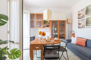 Ein modernes Wohnzimmer mit Esstisch, Stühlen, einer Couch und einem Couchtisch.