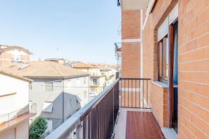 A residential balcony with a view of neighboring houses, a tiled floor, and a metal railing. - Casa Acquamarina in Porto Recanati (Porto Recanati)