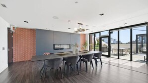 Una cocina moderna con una isla grande, piso de madera oscura y vistas de la ciudad a través de amplios ventanales.