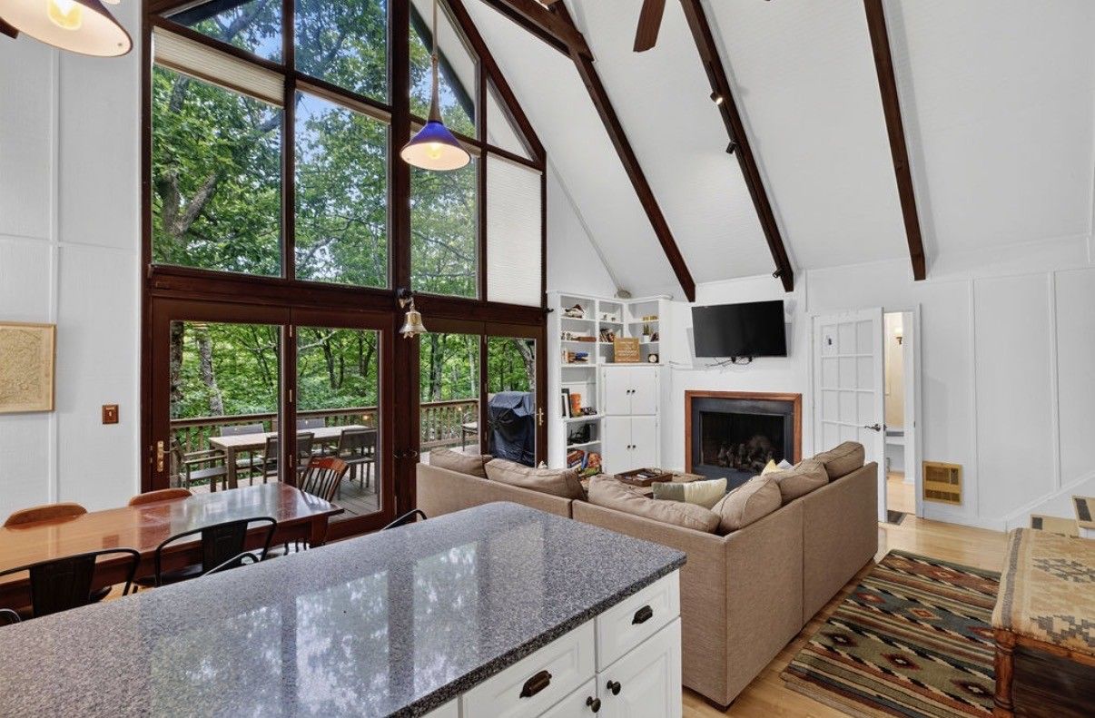 Ein modernes Interieur mit Kücheninsel, Sitzgelegenheit und Kamin.