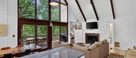 A modern interior with a kitchen island, seating area, and a fireplace.