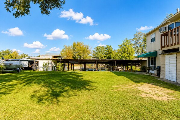 A residential property with a covered patio, a boat trailer, and a garage.