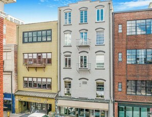 A multi-story building with a ground-floor storefront labeled 'spa-theology.' - The Asheville Jewel Downtown Asheville 1BR with queen bed, full kitchen, Wi-Fi, and elevator. (Asheville)
