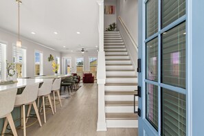 A modern kitchen with a dining area, a staircase, and a view of the outside. - BeachVillaII-14G, ArcadeGames,5B/4.5B, Priv H/C Pool,2Min2Beach,Deck&Gulf views (Panama City)