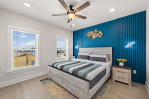 A bedroom with a bed, a nightstand, a ceiling fan, and a window with blinds. - BeachVillaII-14G, ArcadeGames,5B/4.5B, Priv H/C Pool,2Min2Beach,Deck&Gulf views (Panama City)