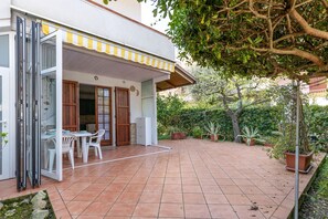 A house with a patio, a dining area with chairs, and a garden with potted plants. - Veranda sul Conero in Marcelli (Numana)
