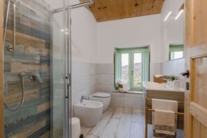 A bathroom with a glass shower enclosure, a bathtub, a toilet, and a sink with a mirror. - Zena Apartment in Cingoli (Cupramontana)