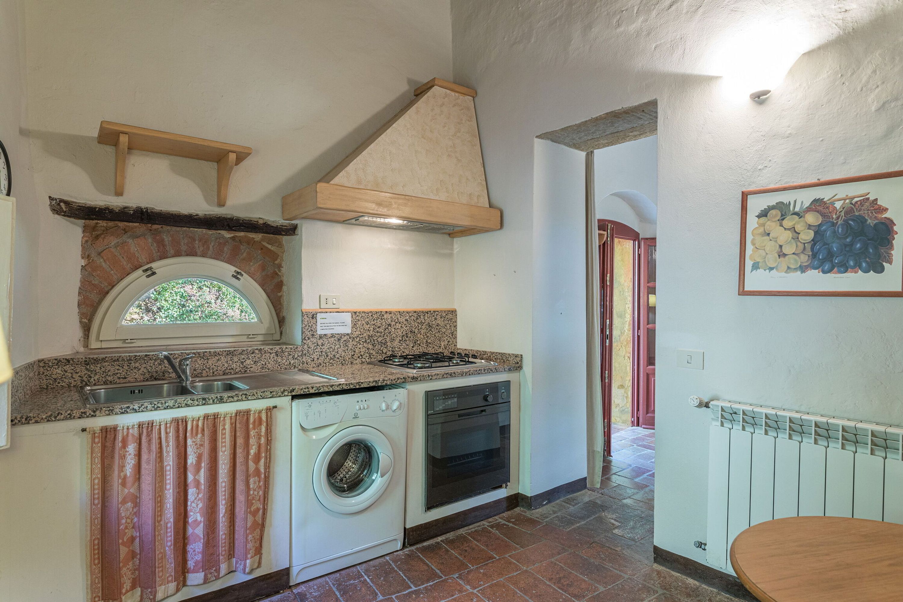 A compact kitchen with a built-in washing machine, a stove, and a sink.