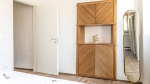 A bedroom with a wardrobe, a mirror, and a bedside table. - Suite Sinfonia Oro in Bevagna (Bevagna)