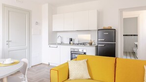 A compact living space with a kitchenette, a dining area, and a sofa. - Suite Sinfonia Oro in Bevagna (Bevagna)
