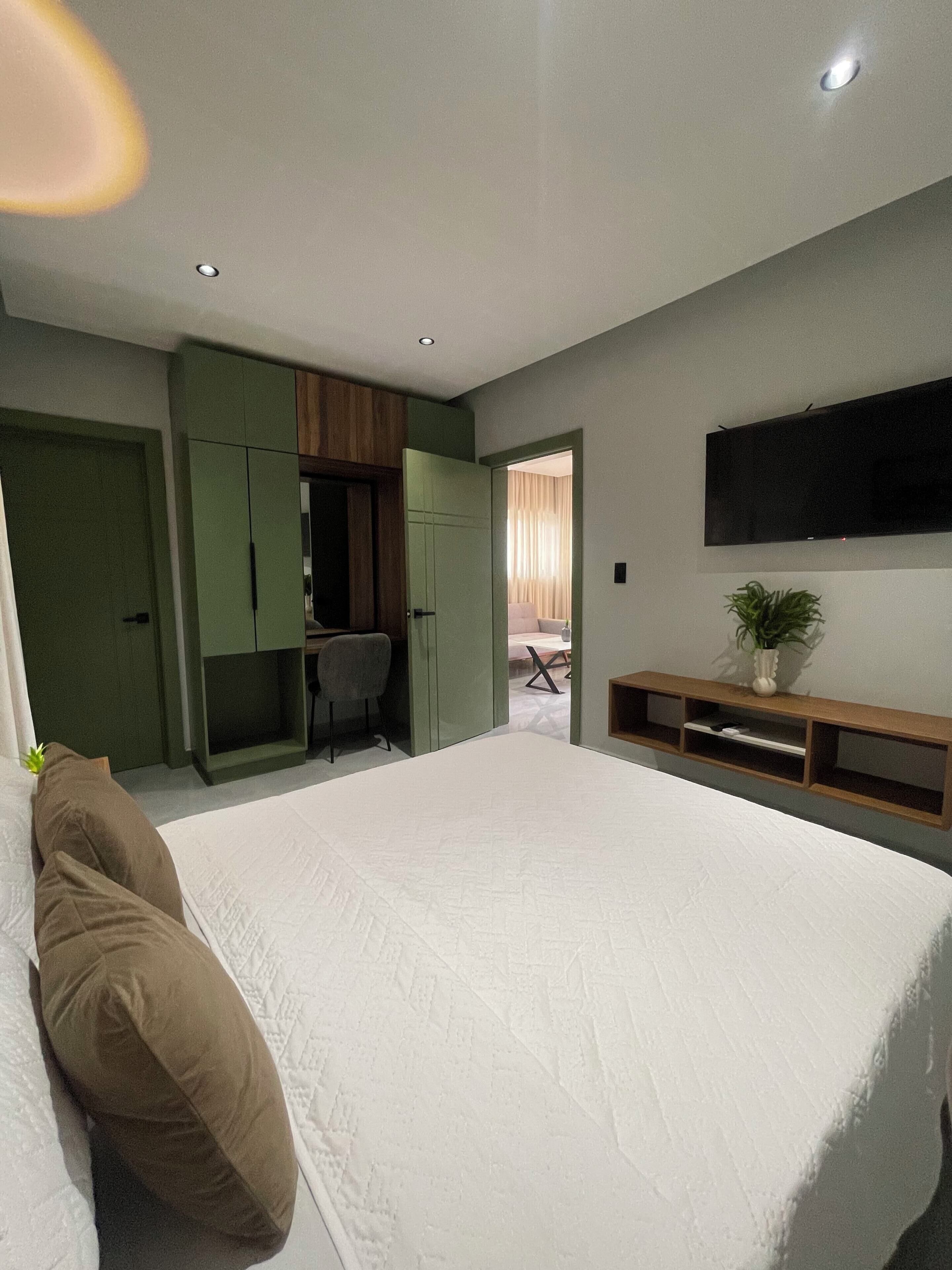Una camera da letto con un letto grande, una scrivania e una televisione.