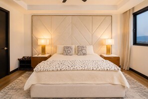 A bedroom with a large bed, two bedside tables, a headboard, and a window with curtains. - Las Ramblas 3 Bedroom Penthouse (Santa Tecla)