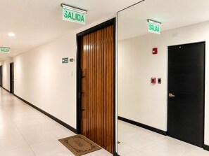 A hotel corridor with doors marked 'SALIDA' and a fire alarm on the wall. - Las Ramblas 3 Bedroom Penthouse (Santa Tecla)