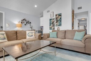 A living room with a sofa, a coffee table, and wall art. - Lakefront Home - 3BR With Boat Dock (Marble Falls)