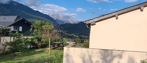 Un quartier résidentiel avec des maisons, une pelouse et une montagne en arrière-plan.