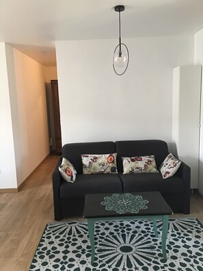 A living room with a black sofa, patterned cushions, a glass coffee table, and a geometric rug. - At the foot of the Hautacam climb (Ayros-Arbouix)