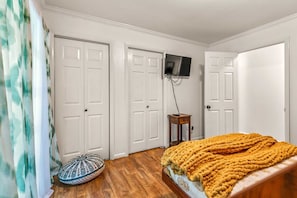 A bedroom with a bed, a television mounted on the wall, and a door. - Private Home on 3 Acres! 5 Bedrooms - Private Hot Tub - Close to Strip! | Silver Creek (Branson)